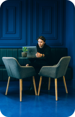 Homme travaillant sur un ordinateur portable dans un espace moderne, symbolisant la création de sites web sur-mesure et l'innovation digitale.