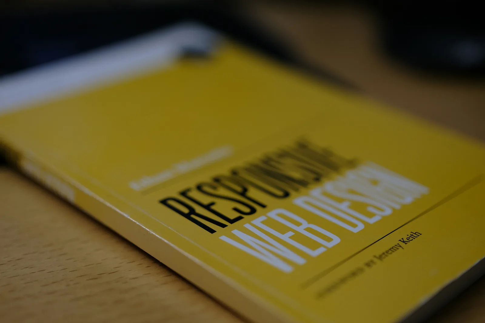 Livre jaune sur le responsive web design posé sur un bureau